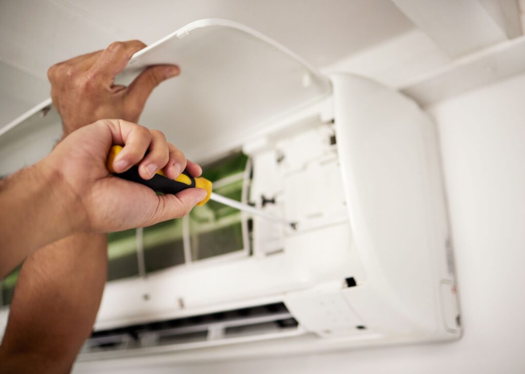 technician fixing an ac unit